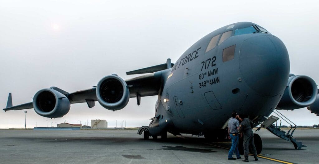 A large military plane sitting on top of an airport runway.