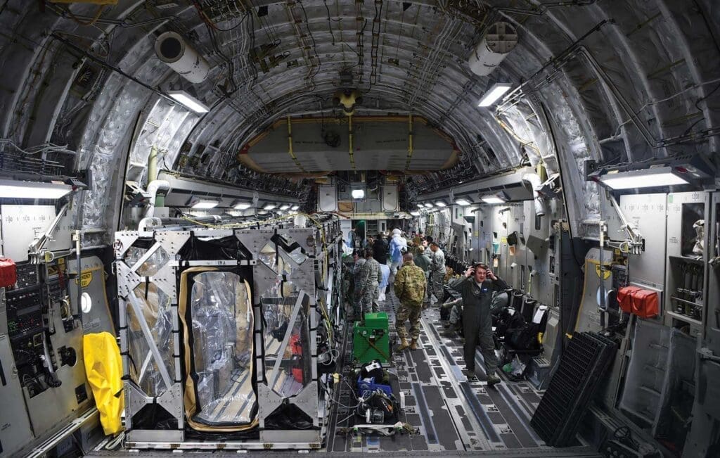 A group of people standing inside of an airplane.