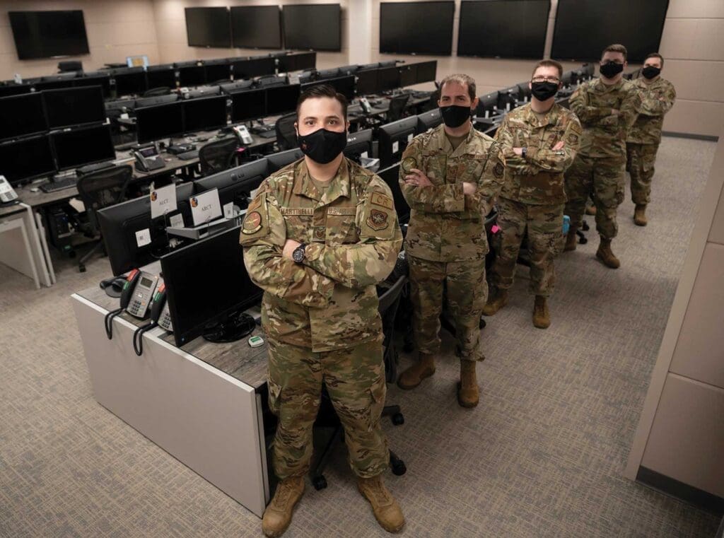 A group of soldiers standing in front of computers.