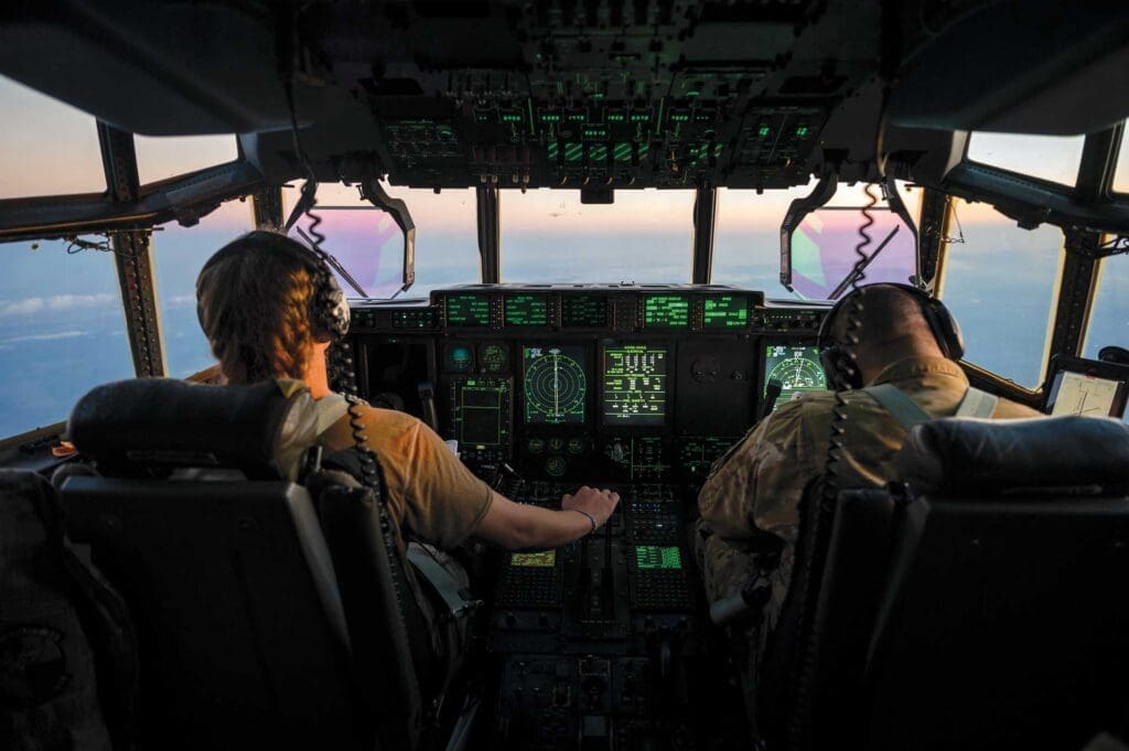 Two pilots are flying a plane in the sky.