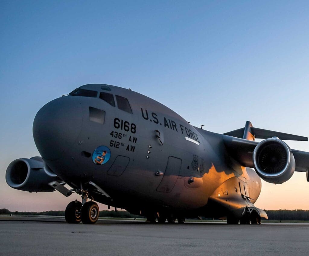A large military plane sitting on top of an airport runway.
