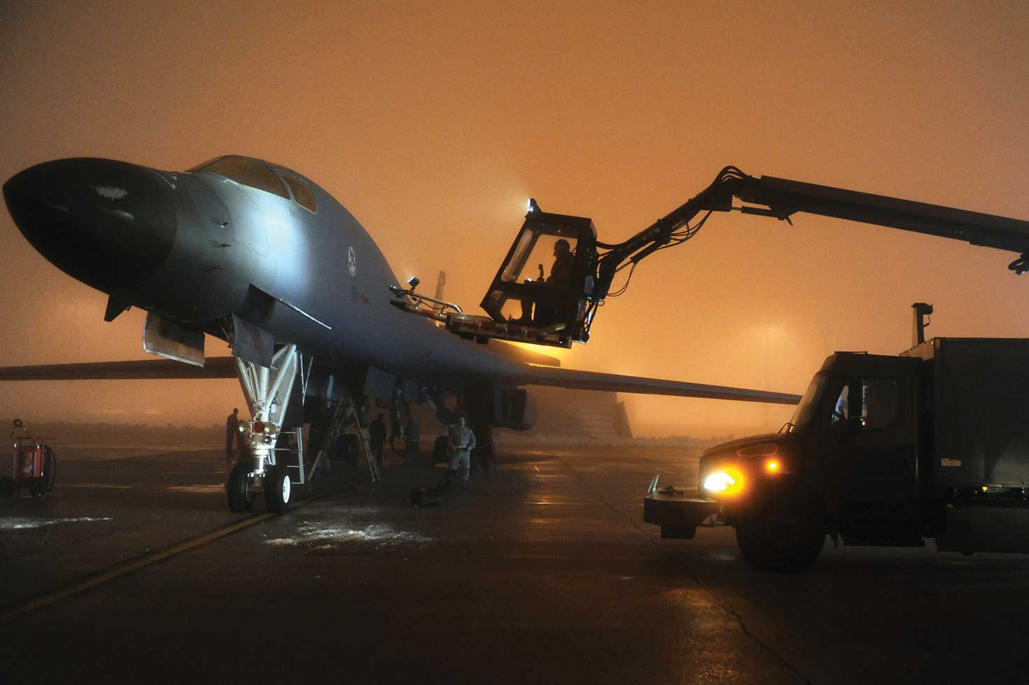 A plane being worked on the runway at night.