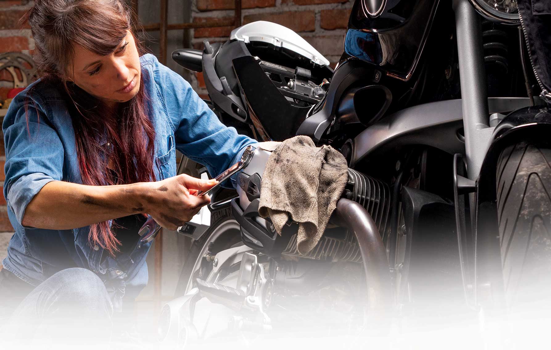 Woman repairs a motorcycle.