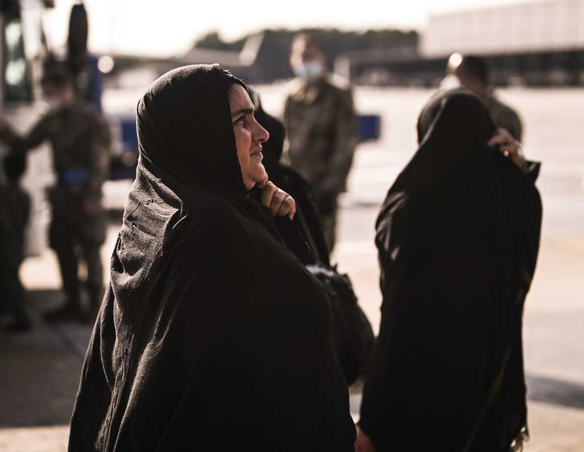 A woman in black is standing next to another person.