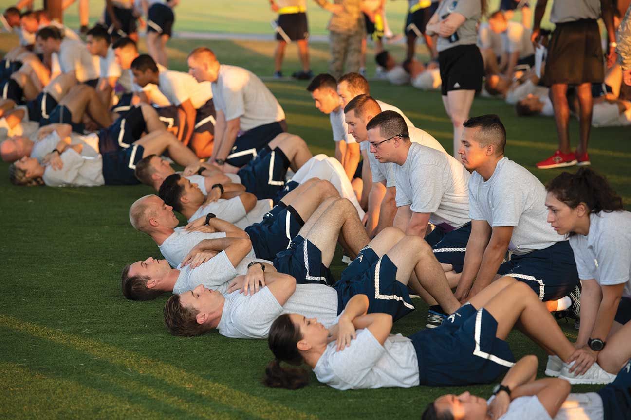 A group of men in white shirts and shorts on grass.