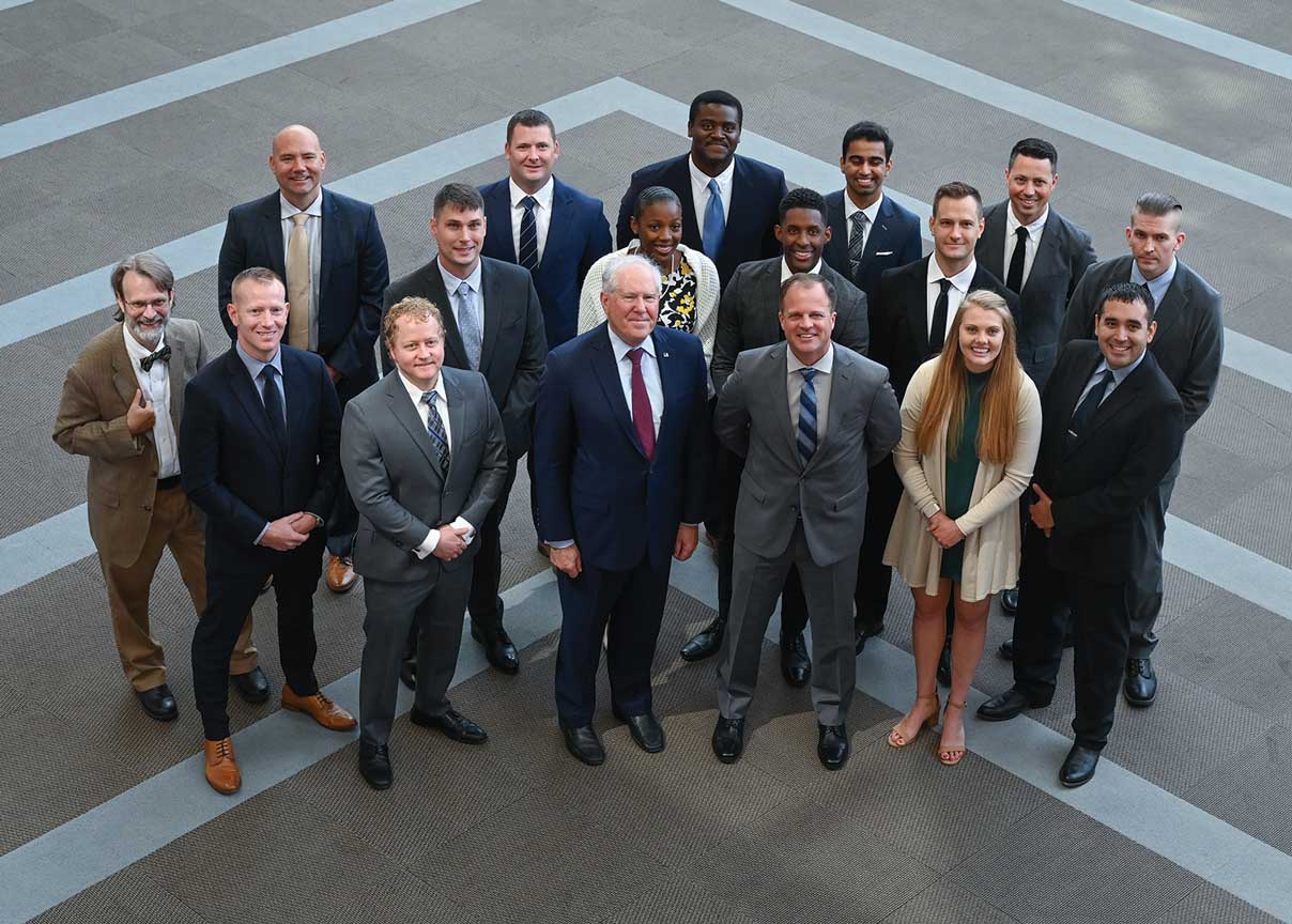 A group of people in suits and ties standing next to each other.