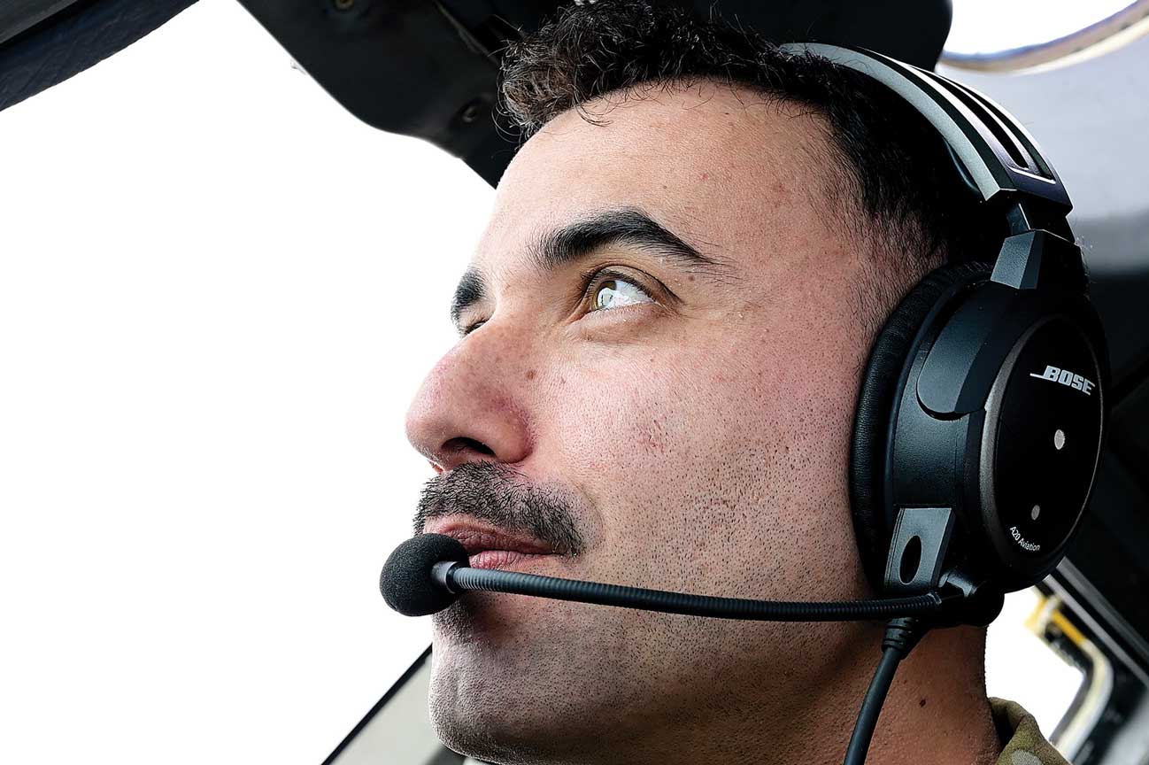 A man with headphones on looking up at the sky.