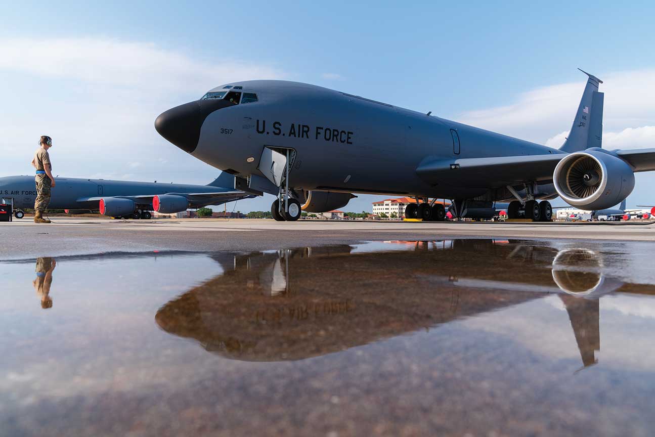 A large military plane sitting on top of an airport runway.