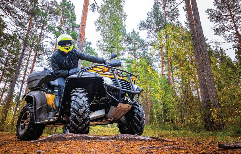 A man riding on the back of an atv.