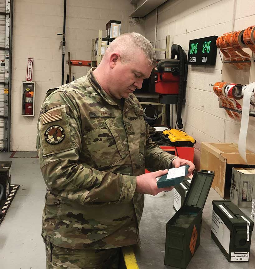 A man in military fatigues looking at an item.