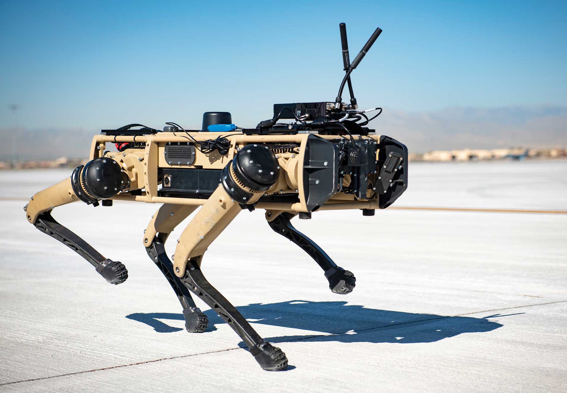 A robot dog is running across the snow.