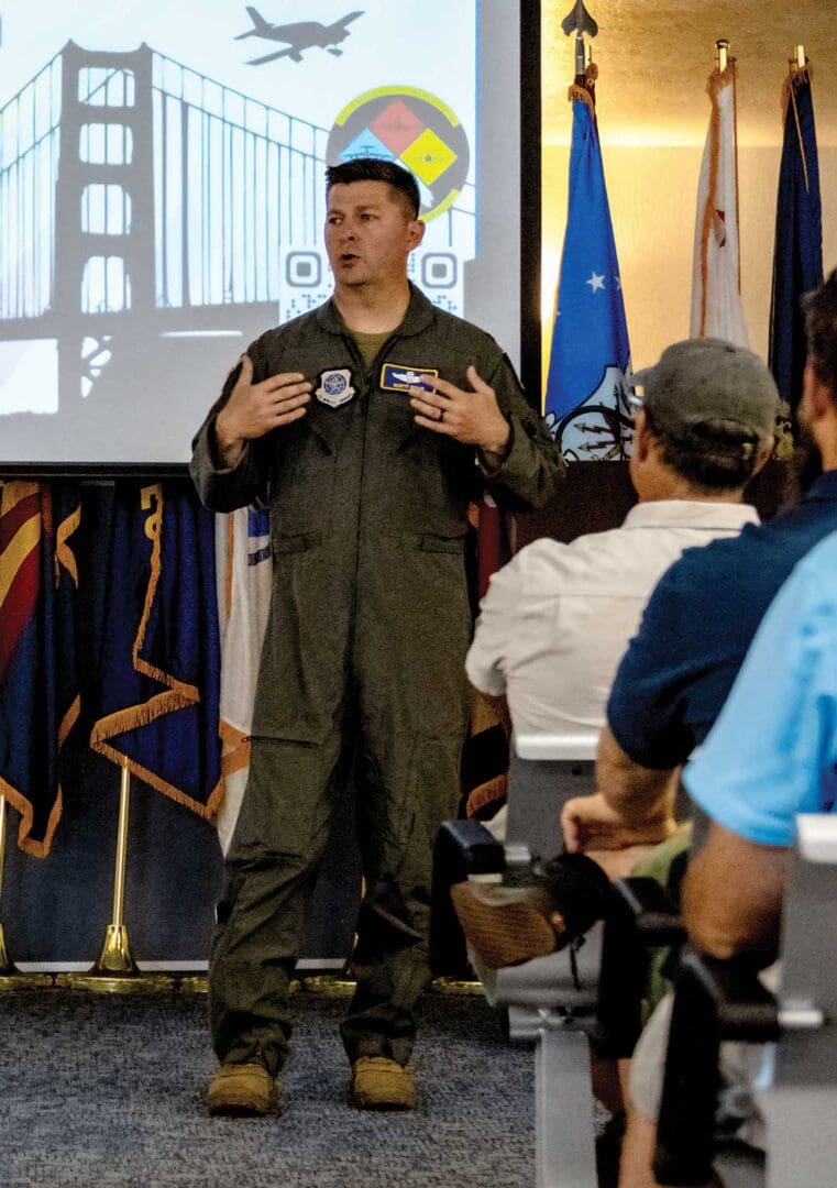 A man in an air force uniform talking to people.