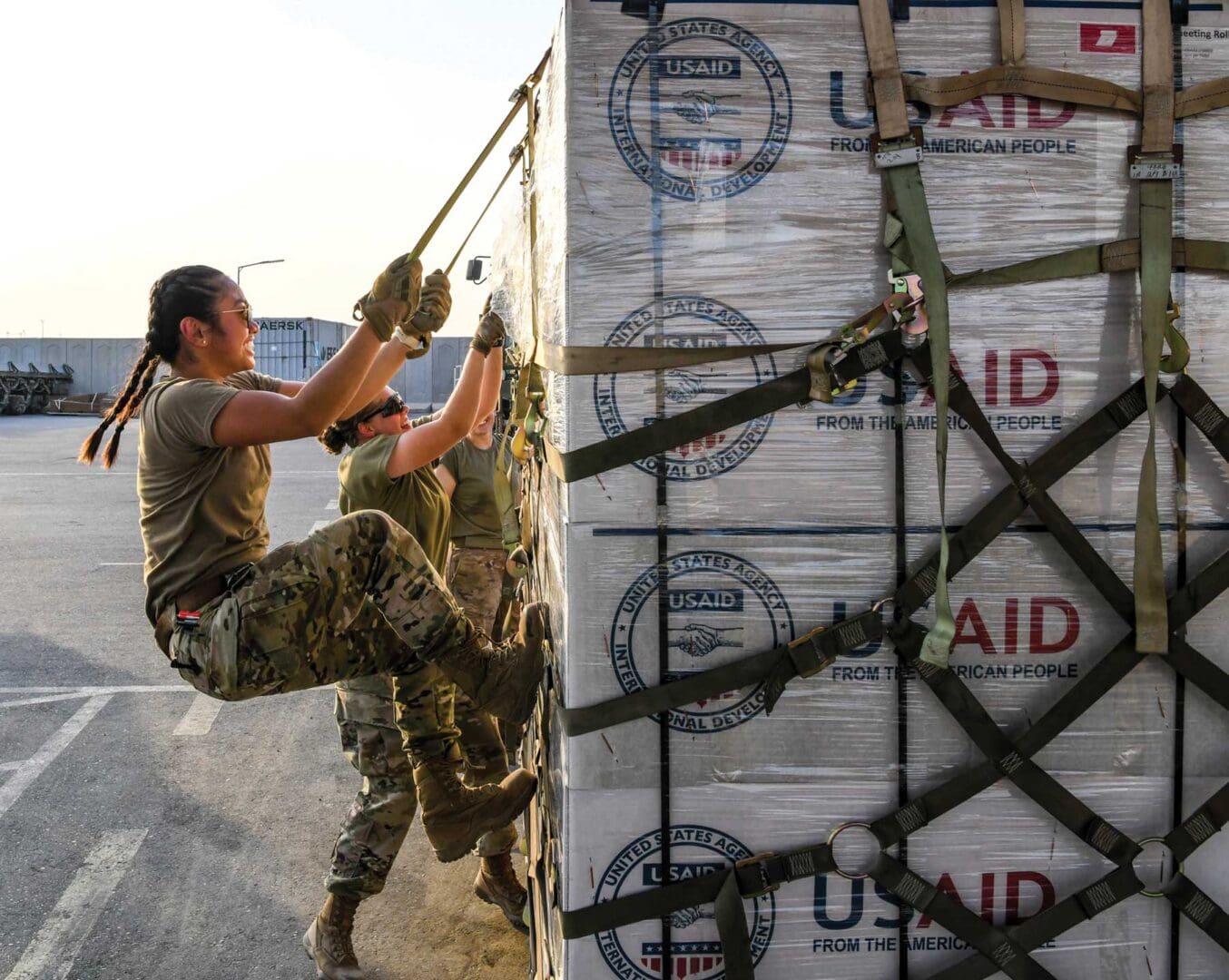 SrA Joana Galang, a Traffic Management Specialist with the 380th Expeditionary Logistics Readiness Squadron, uses her body weight to secure a pallet containing humanitarian relief items from the U.S. Agency for International Development, September 8, 2022, at Al Dhafra Air Base, United Arab Emirates. USAF photo by TSgt Jeffrey Grossi