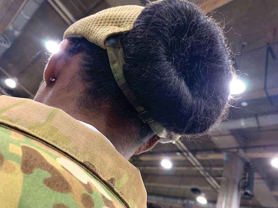 A member of the 436th Airlift Wing demonstrates how a bun fits into the newly designed unisex bump cap at the Airlift/Tanker Association Conference in Grapevine, TX, Nov. 9, 2023. The new bump cap was created by SSgt Sheila Moody, 436th Aircraft Maintenance Squadron Air Force Repair Enhancement Program Aircraft Structural Journeyman and SSgt Cortnee Madrid, 436th Aircraft Maintenance Squadron Dock Chief. USAF photo by SSgt Sheila Moody