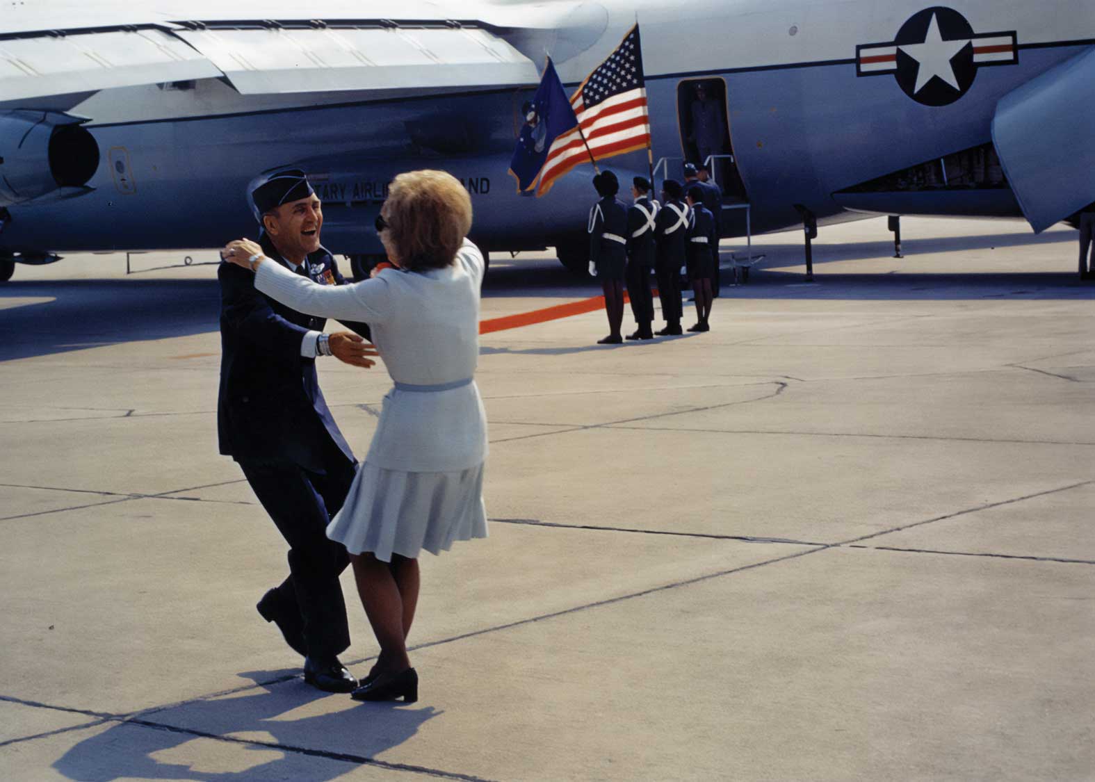 Just off the plane Col Day greets his wife with a big hug.