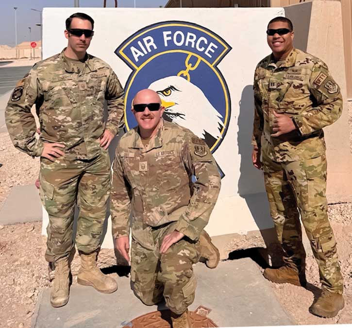 Three men in military uniforms posing for a picture.