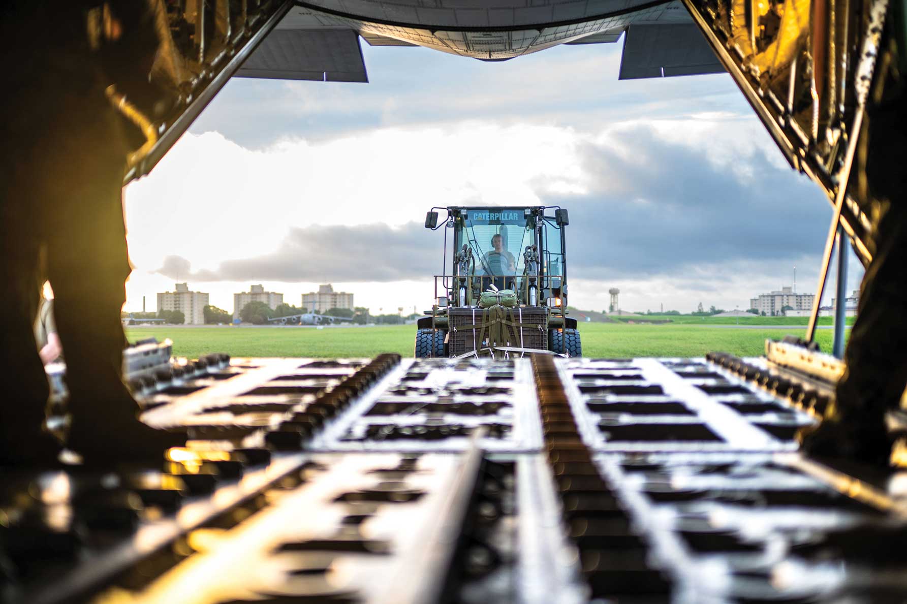 Airmen load container delivery systems onto a C-130J Super Hercules aircraft.