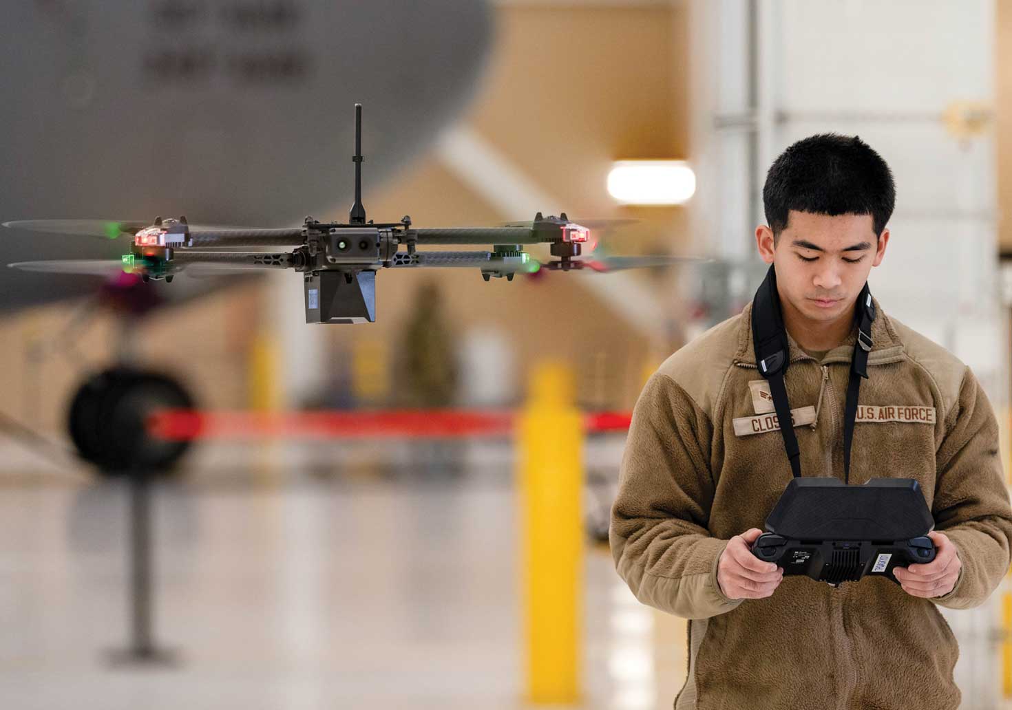 SrA Mathew Closas flies a drone in a hangar at Travis Air Force Base, CA.