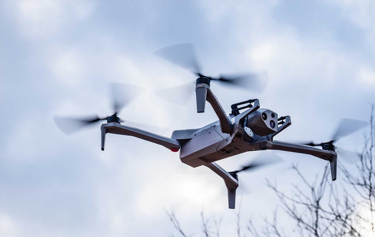 A Small Unmanned Aircraft Systems vehicle hovers midair.