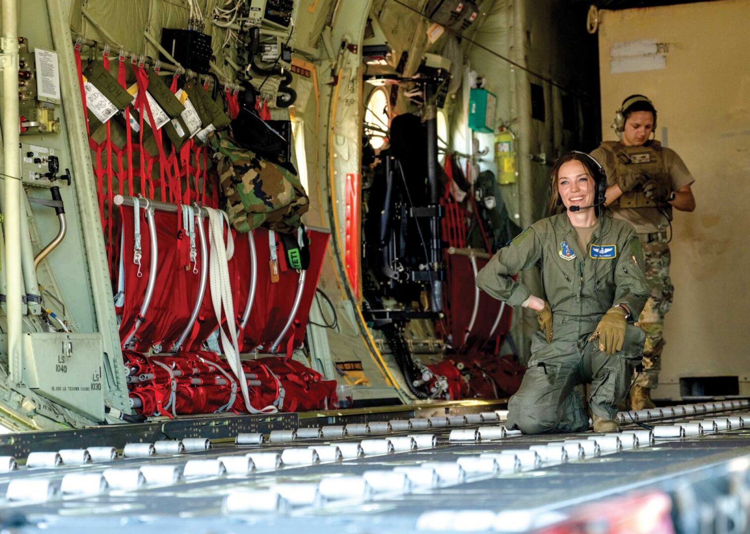 TSgt Emily Knight waits for the next pallet of cargo to be loaded onto a C-130J Super Hercules aircraft.