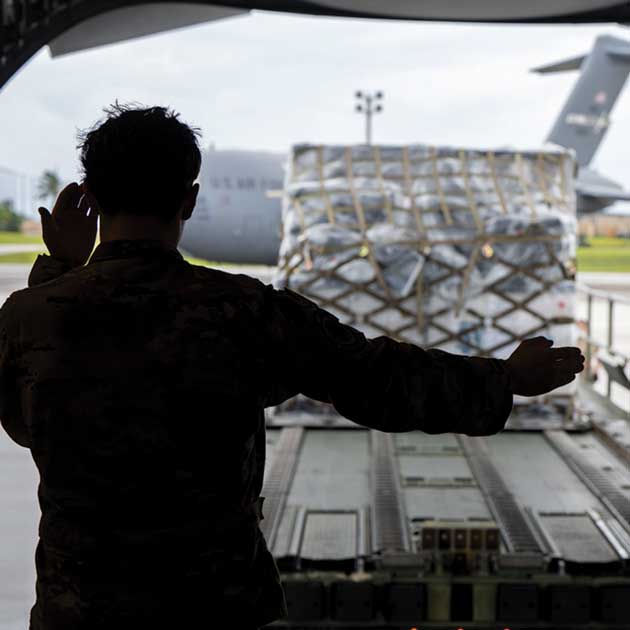 A1C Payton Cornell guides cargo to be loaded onto a C-17 Globemaster III aircraft.