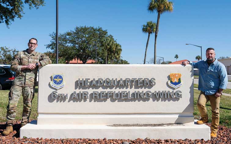 MSgt Garrett Craig and Mr. Jason McLeod stand by the sign for 6th Air Refueling Wing Headquarters.
