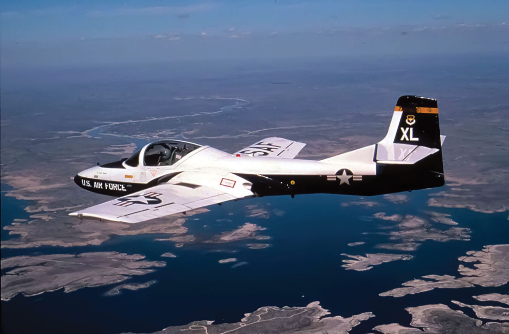 A T-37 Tweet aircraft from the 85th Flying Training Squadron, Laughlin Air Force Base, Texas, flies over Lake Amistad during a training mission.